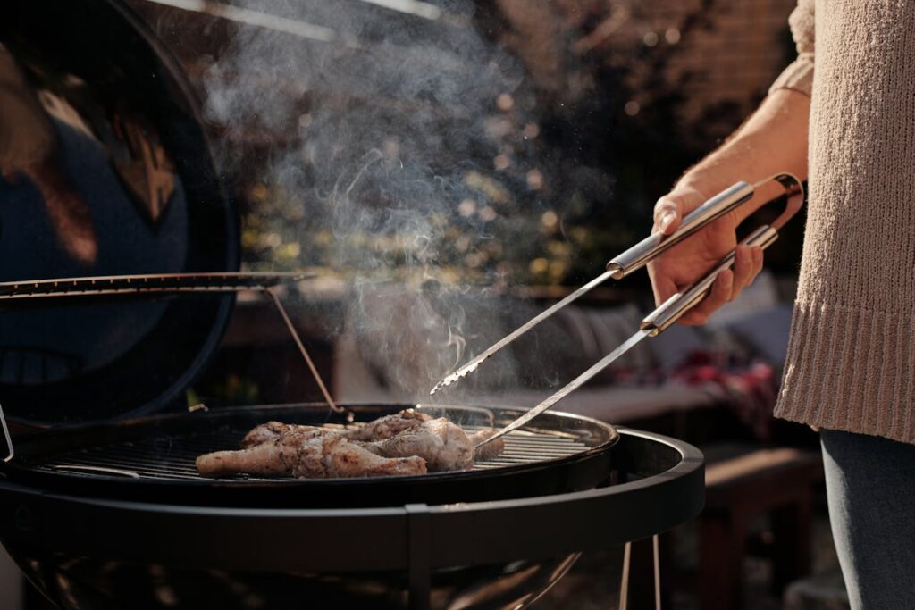 Close-Up Shot of a Person Grilling Chicken
