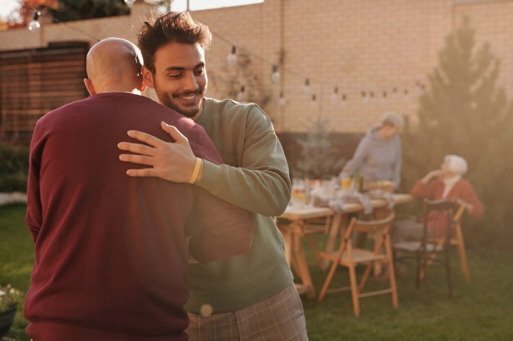 Smiling Men Hugging at Garden