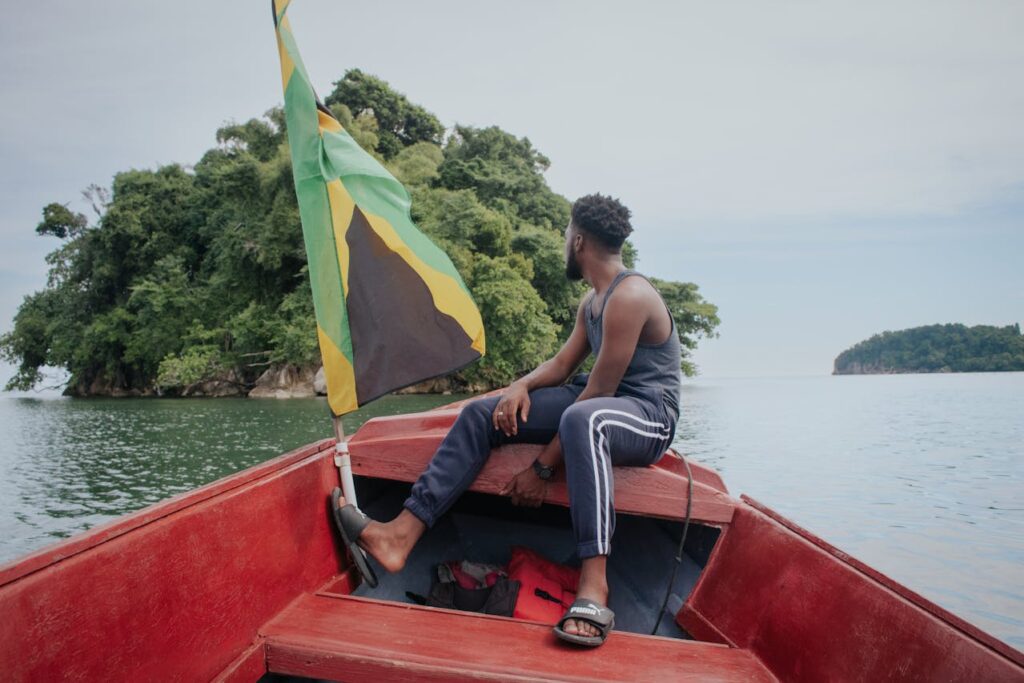 Man Sitting on Boat with Jamaican Flag
