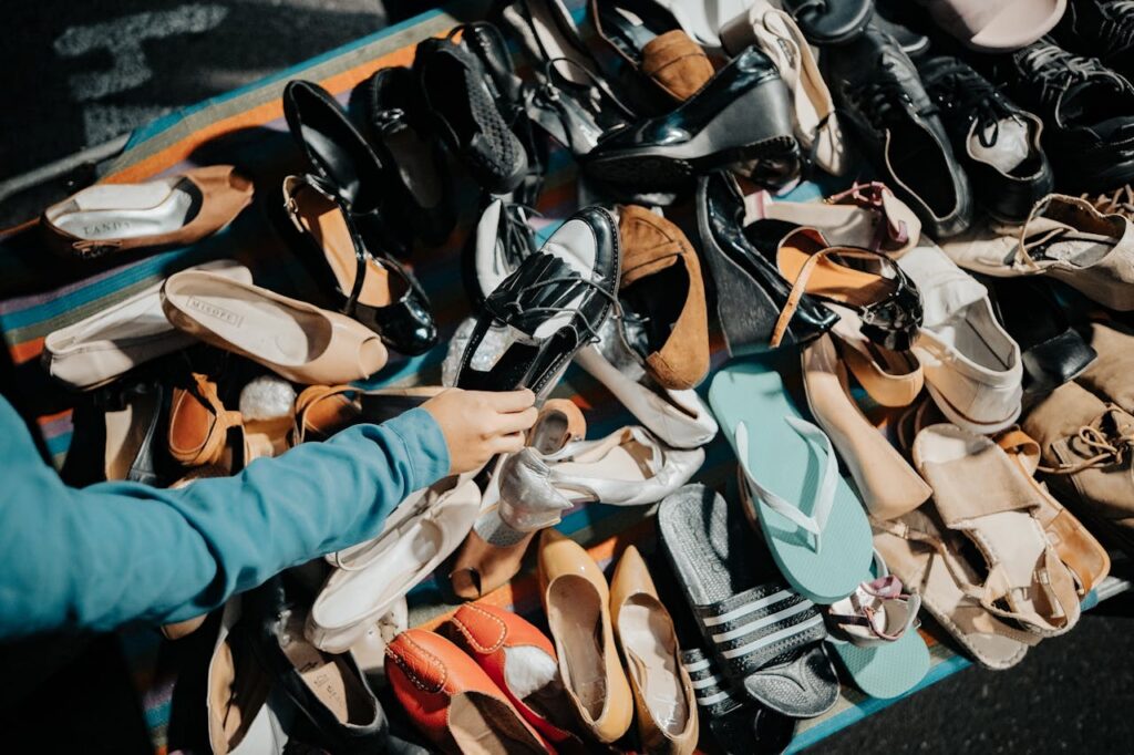 Hand Picking Up Shoes at Market

