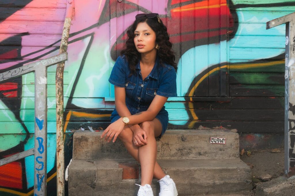 Young Woman Posing Against Colorful Urban Graffiti
