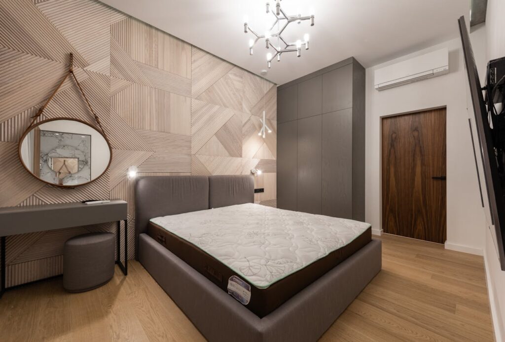 Bedroom interior with bed near table with pouf under mirror
