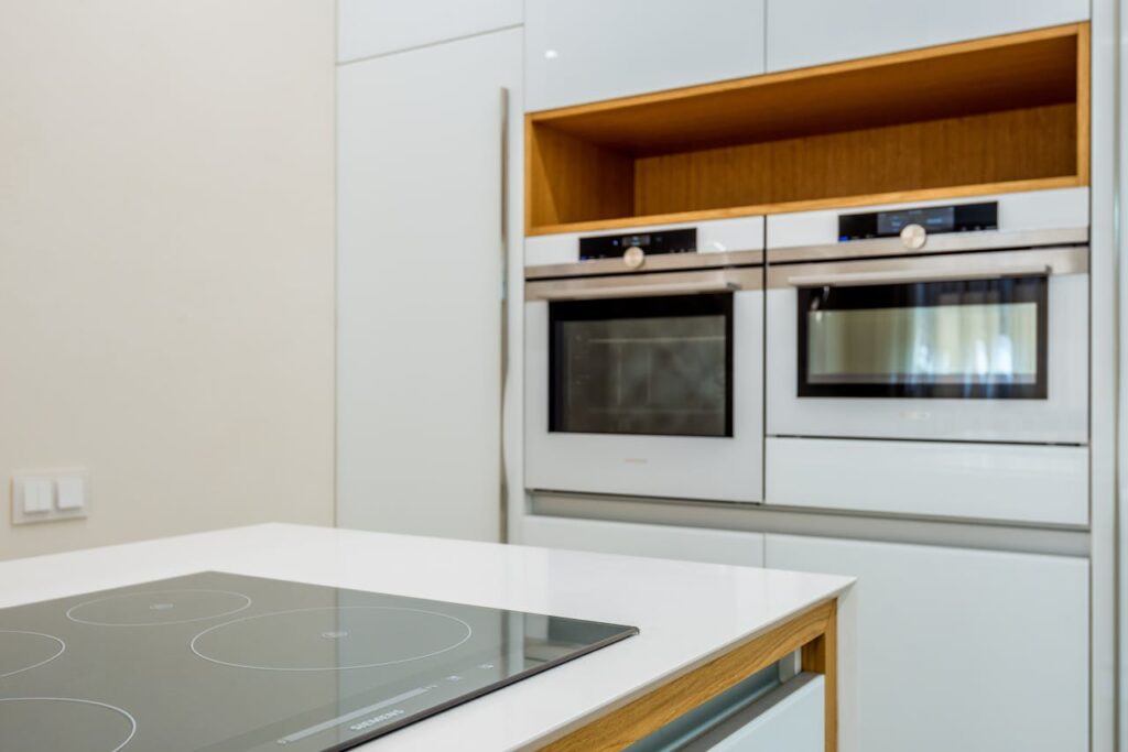 Modern ovens placed in light kitchen