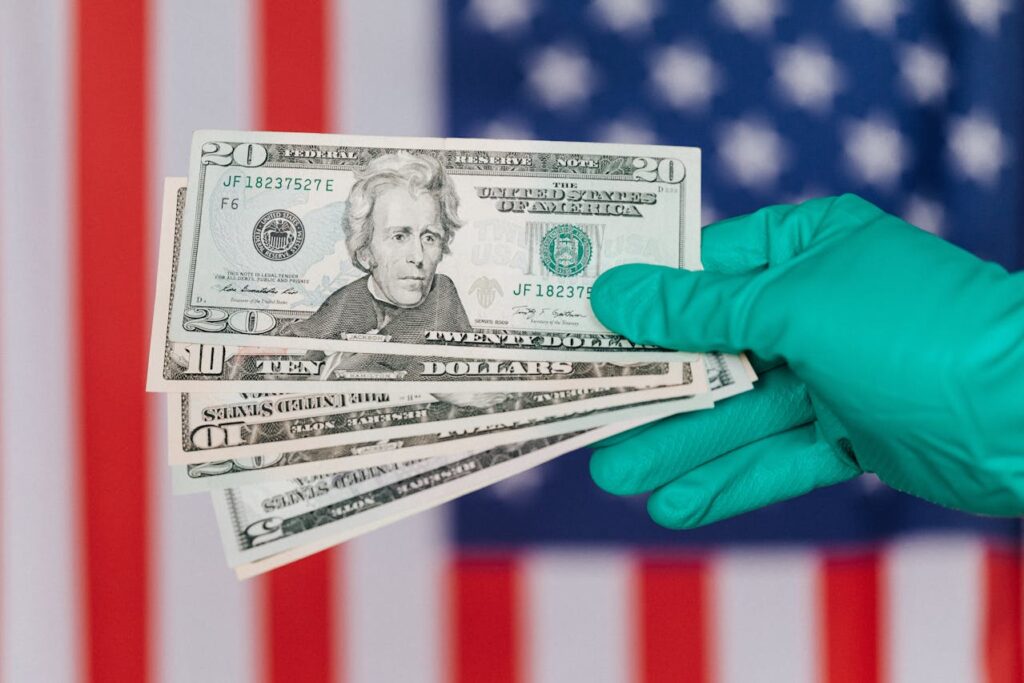 Banknotes of American dollars in hand against flag
