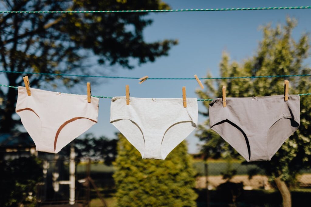 Feminine underwear drying on rope with clothespins on fresh air
