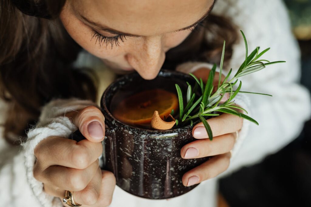Woman Drinking Drink with Orange Slices and Leaves
