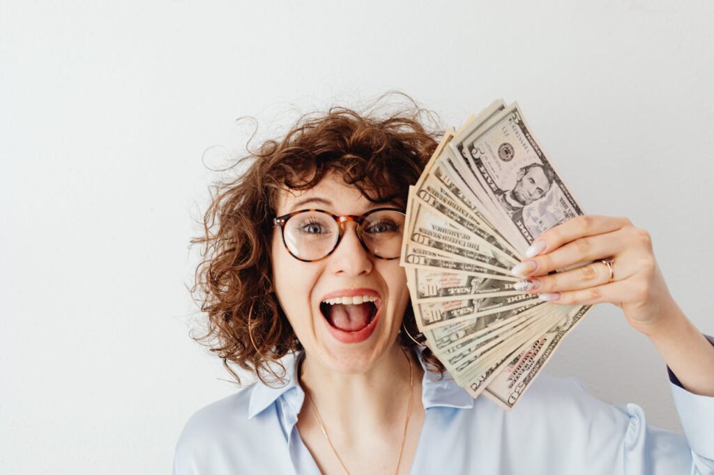Happy Woman in Blue Long Sleeve Blouse Holding Money
