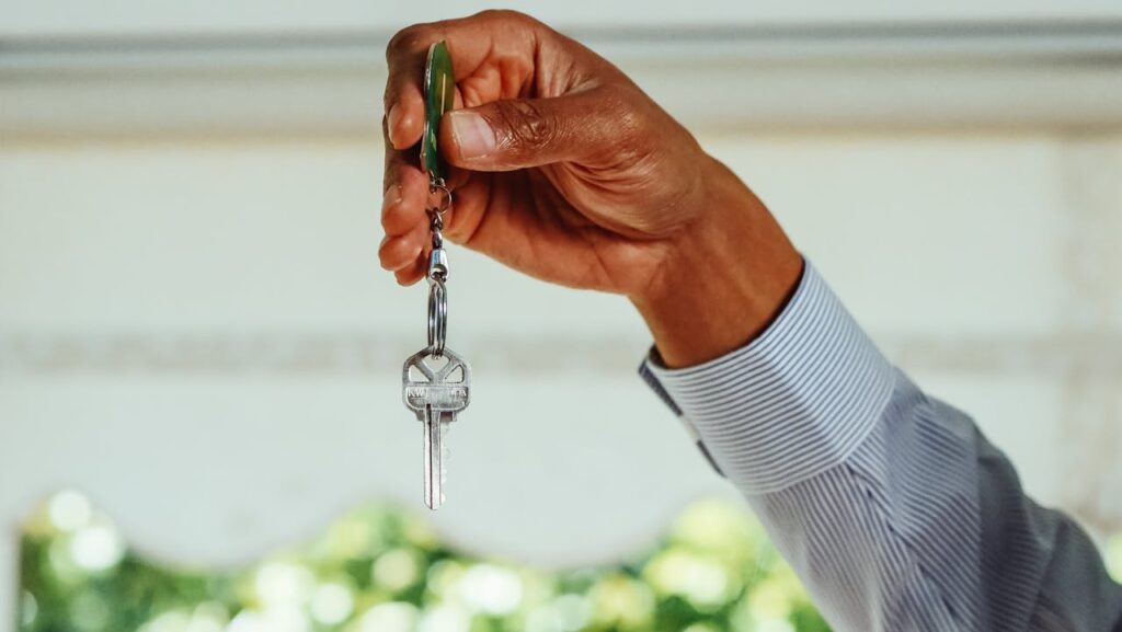 Person Holding Silver Key With Clear Gemstone
