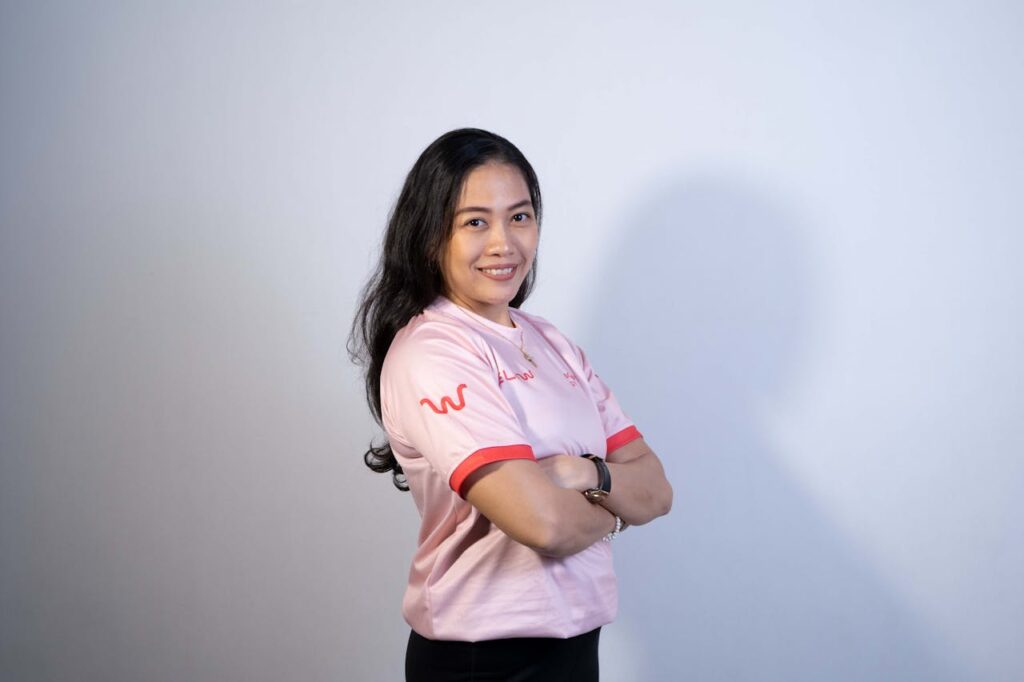 Confident Asian Woman Smiling in Pink Shirt
