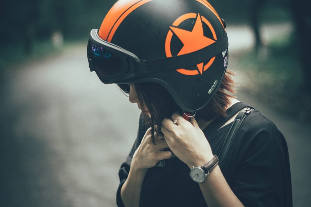 Woman on Black and Orange Half-face Helmet

