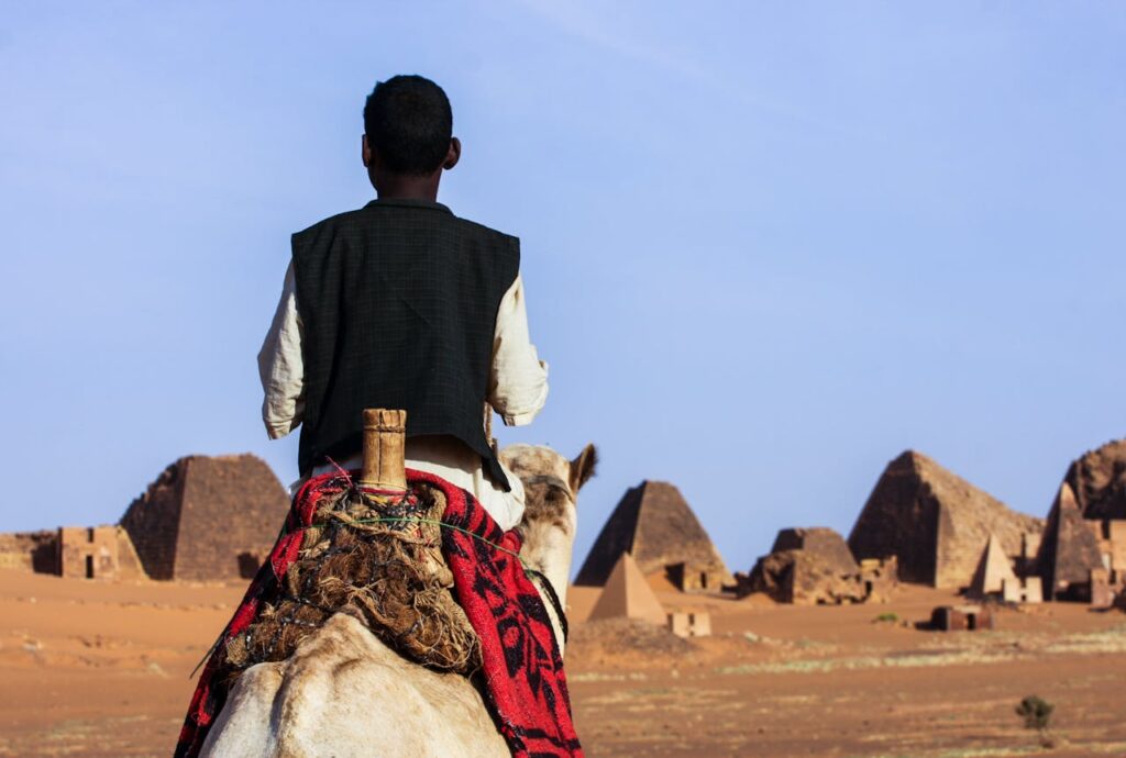Man Riding Camel on Desert
