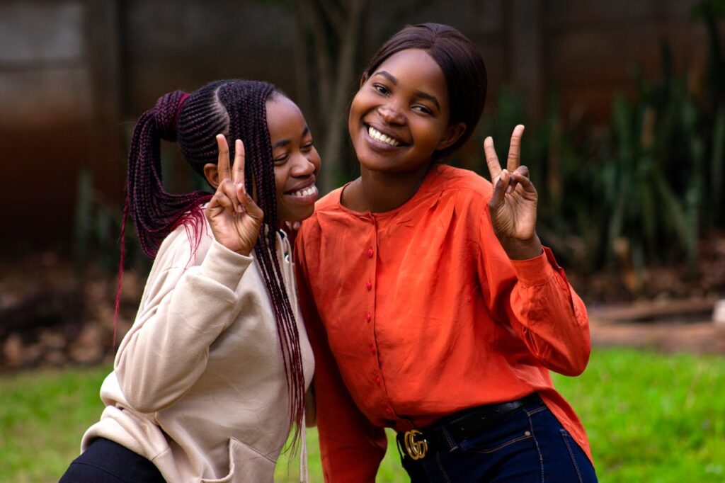 Portrait of Girls Smiling Doing Peace Sign
