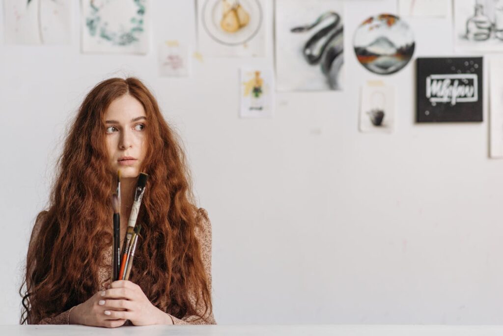 A Redheaded Woman Holding a Paintbrushes
