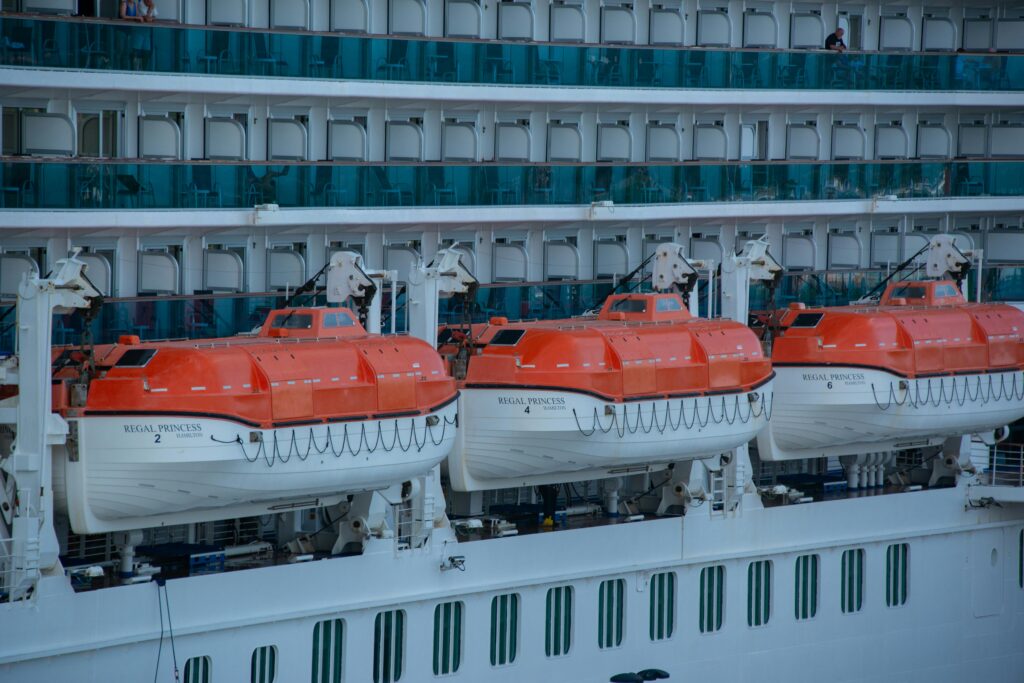 lifeboats attached to the side of a cruise ship.