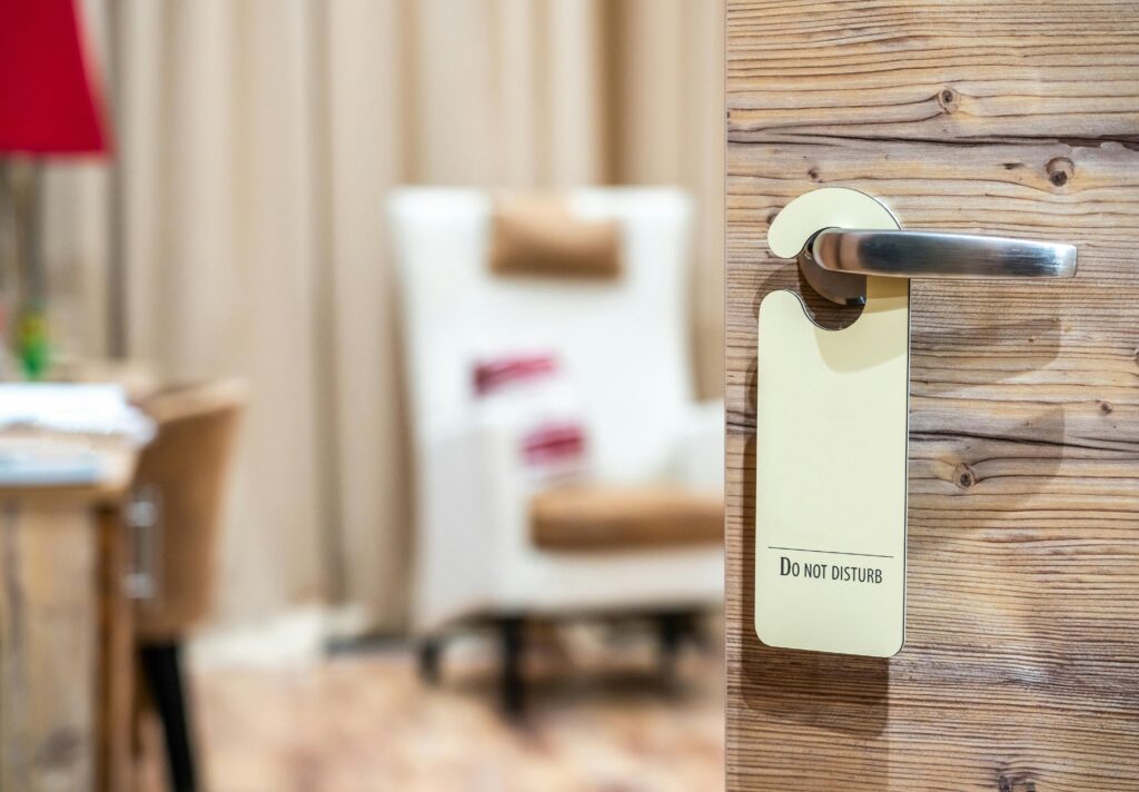 a "Do Not Disturb" sign hanging on a hotel room door handle. 