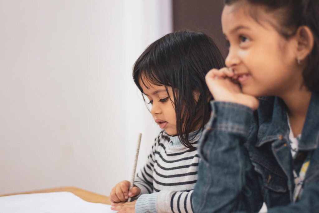 Two Girls Writing on Paper
