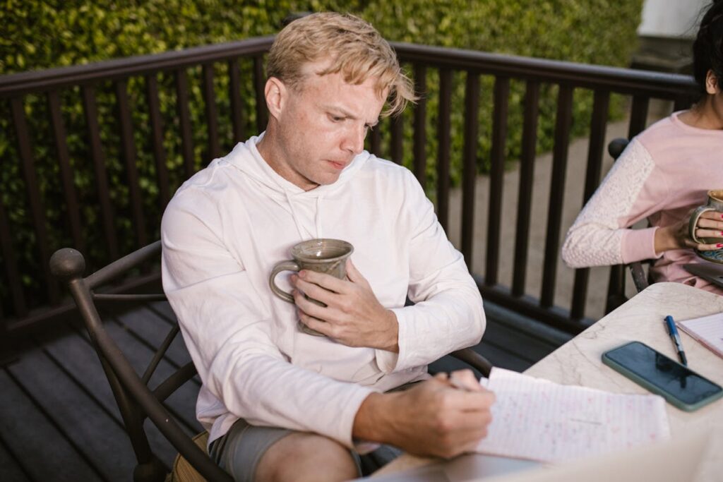 A Man in a White Hoodie Writing