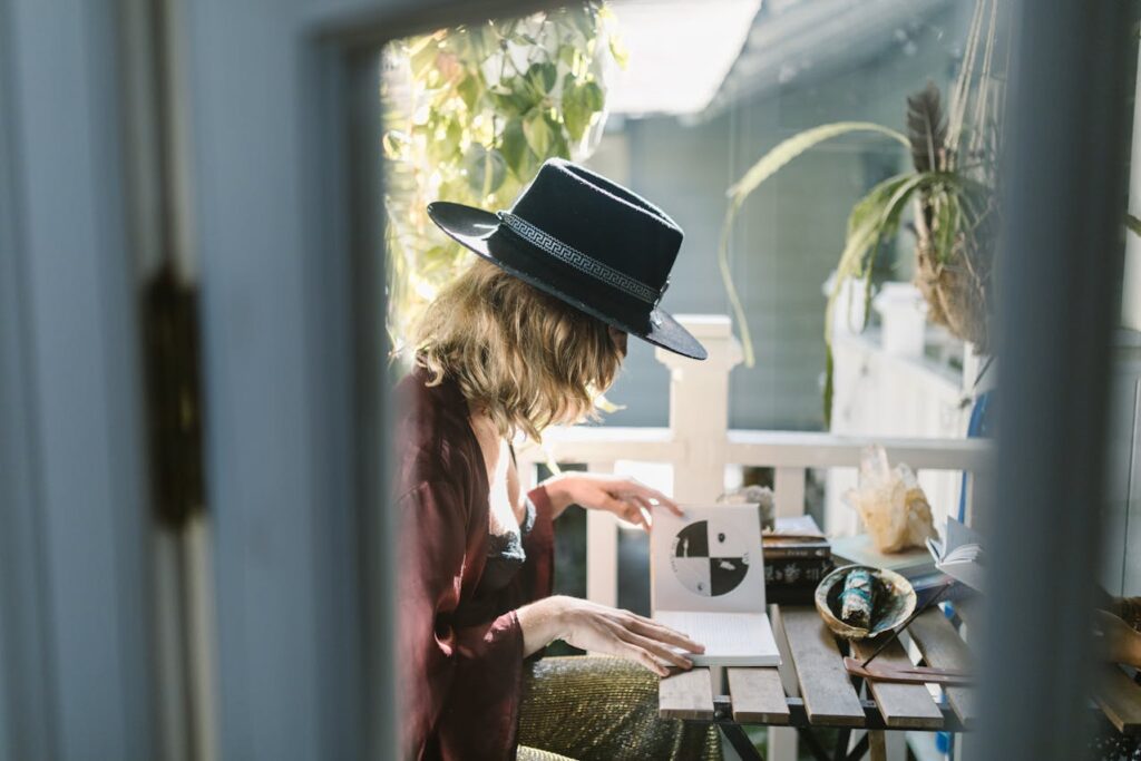 Woman in Red Long Sleeve Shirt and Black Hat Sitting on Chair

