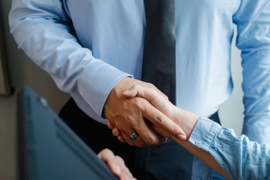 Anonymous colleagues shaking hands before business meeting
