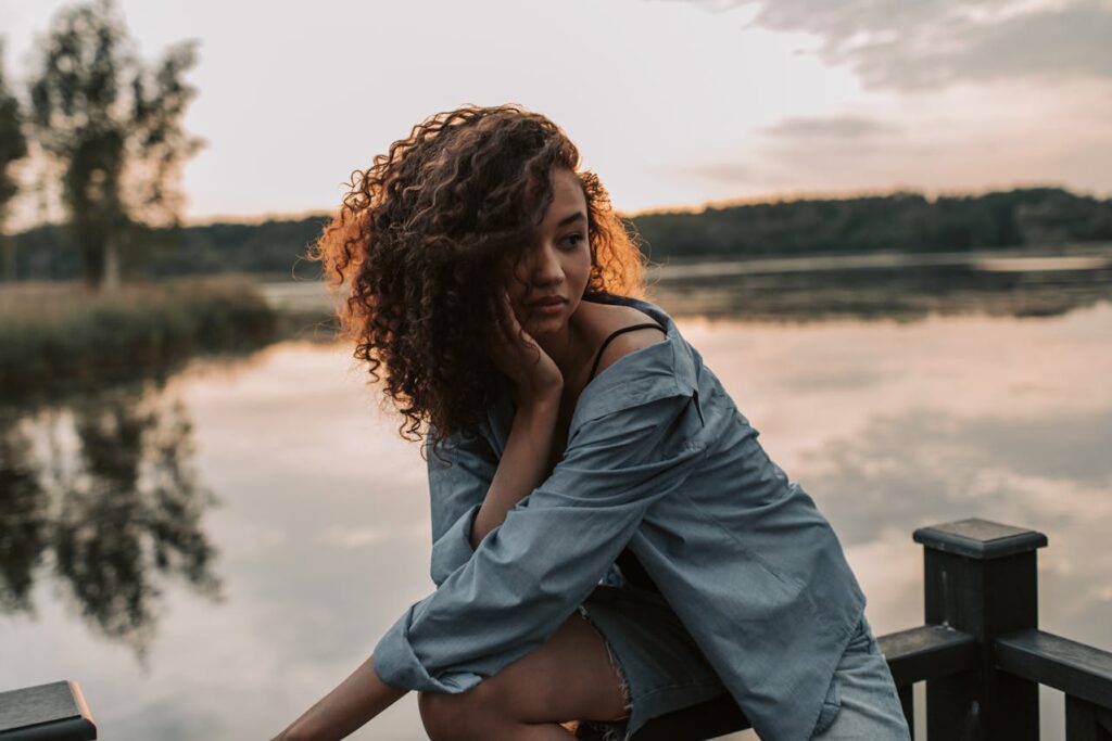 Photo Of Woman Sitting Wooden Handrail
