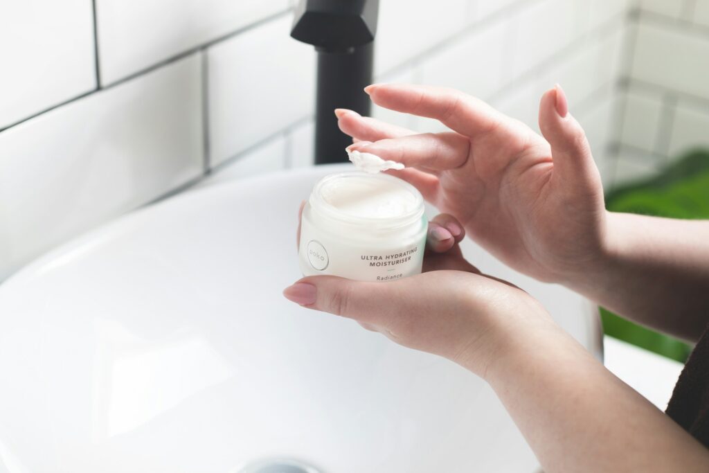 person holding white and black plastic bottle
