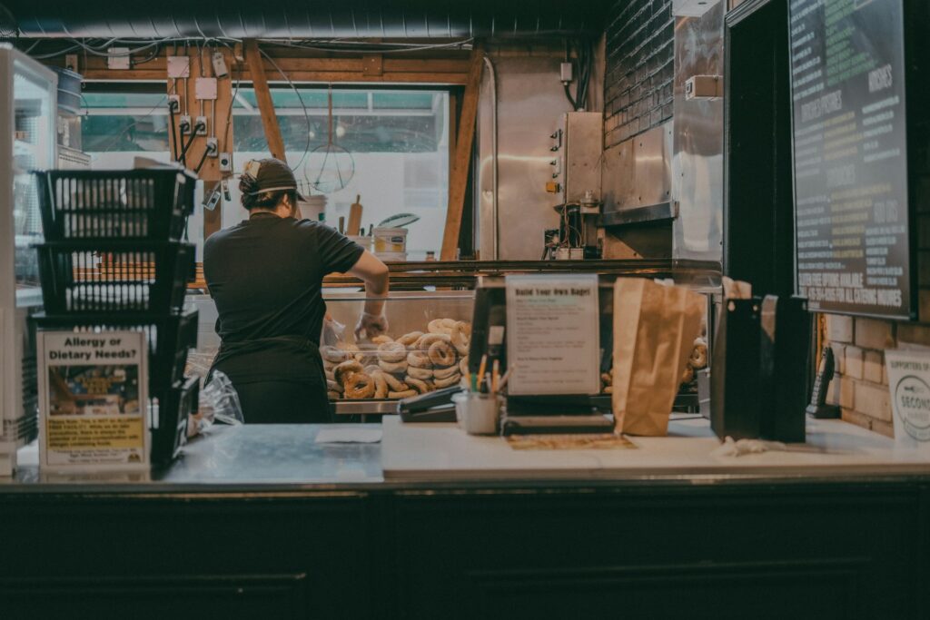 a man standing behind a counter in a restaurant
