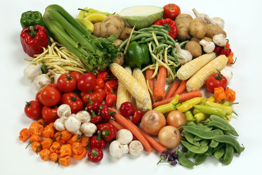 a pile of different types of vegetables on a white surface

