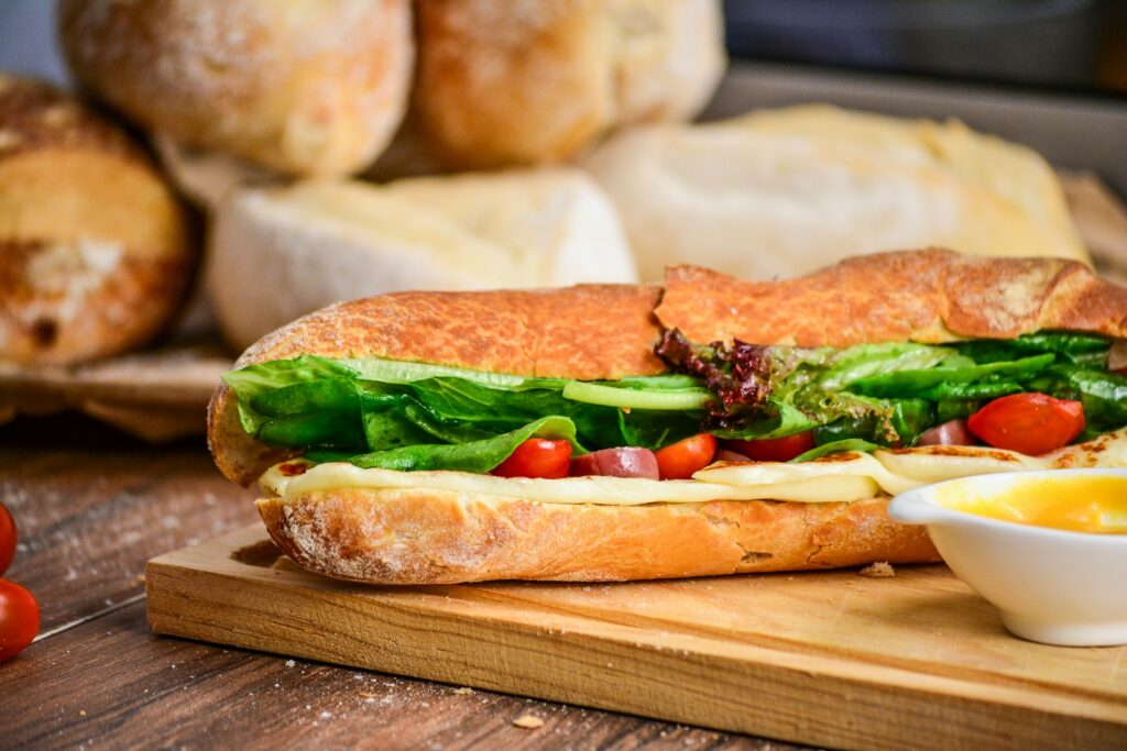 baked bread with vegetable on brown chopping board
