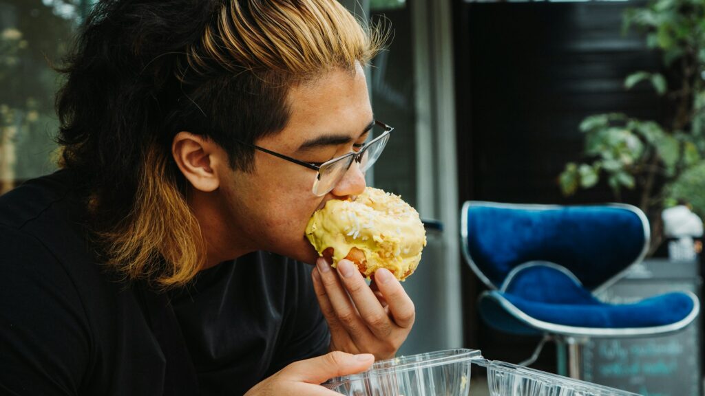 a person eating a pastry
