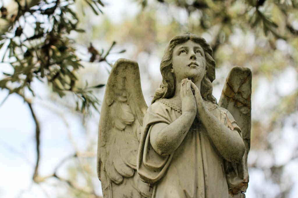 a statue of a person holding a cross
