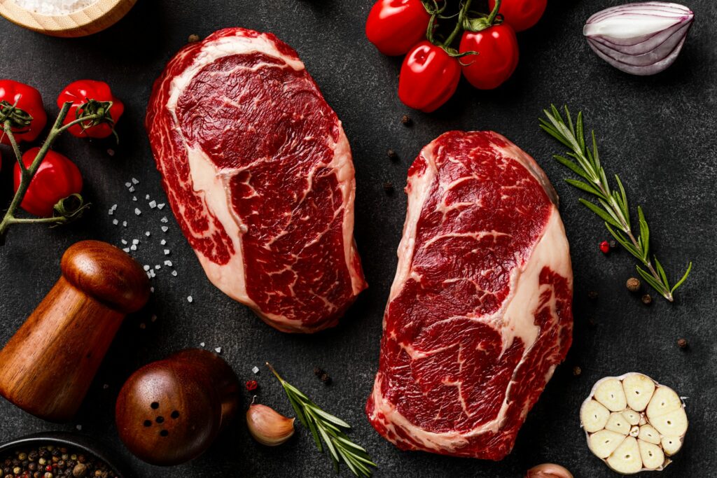 a couple of steaks sitting on top of a table
