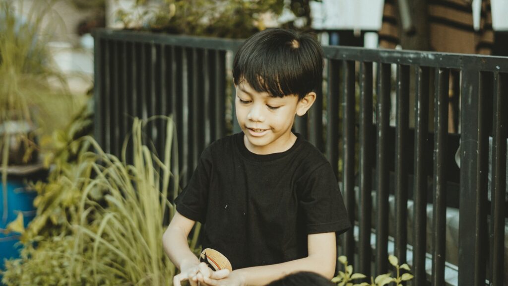 A young boy is standing outdoors.
