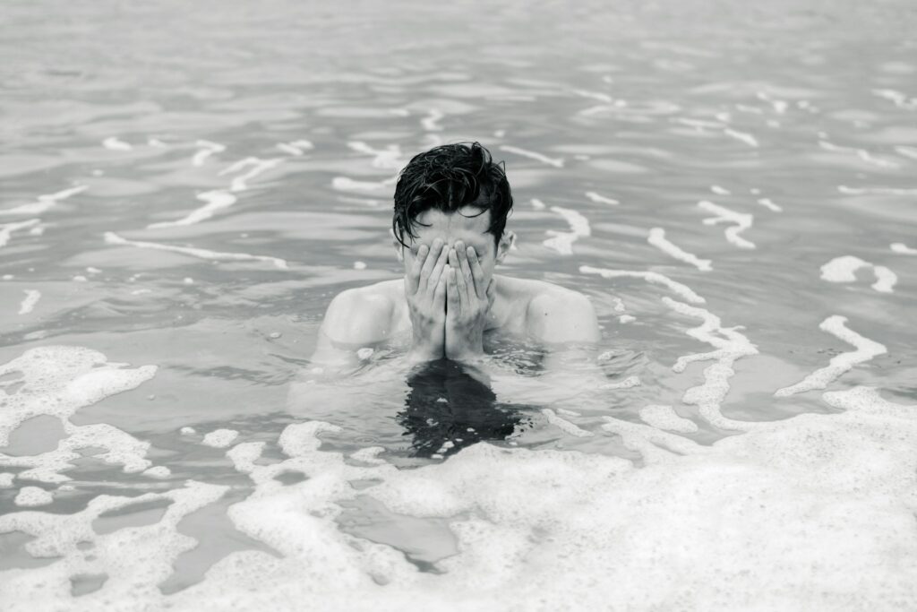 grayscale photo of man on body of water
