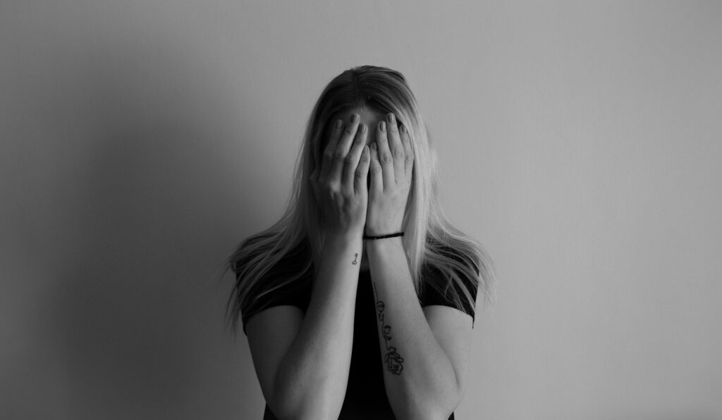 woman covering face with her hands
