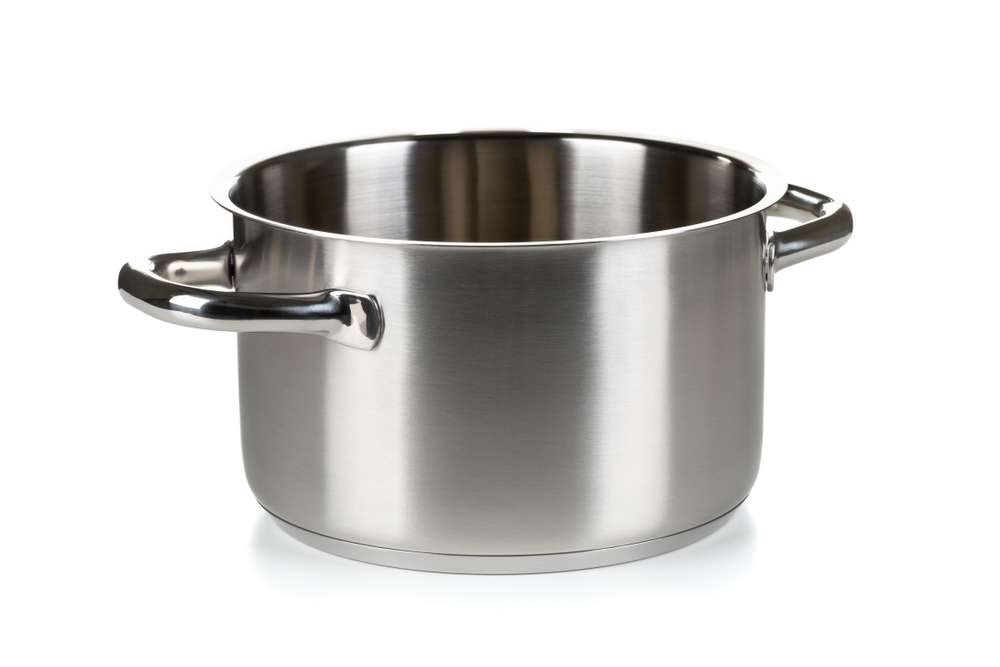 Open stainless steel cooking pot over white background