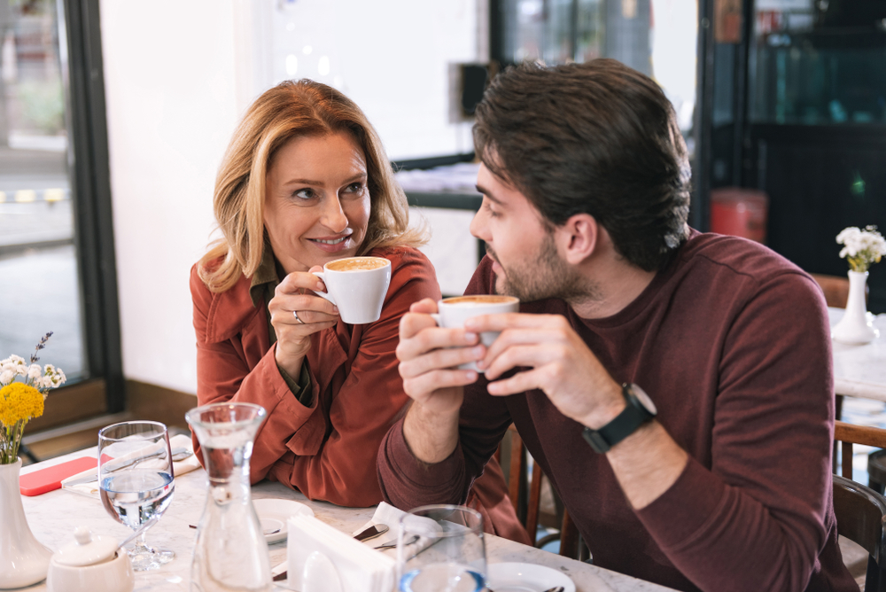 Coffee time. Beautiful adorable couple sipping coffee and chatting