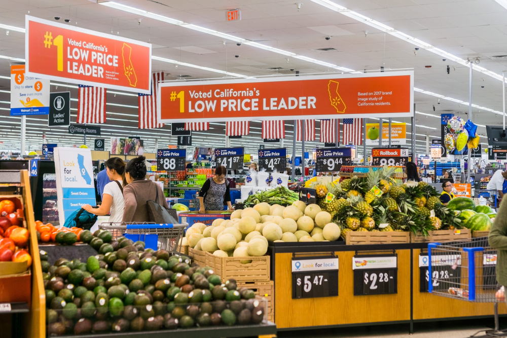 September 4, 2018 San Jose / CA / USA - People shopping in the food and vegetable area of one of Walmart's stores in south San Francisco bay area; Banners advertising the low price leader status