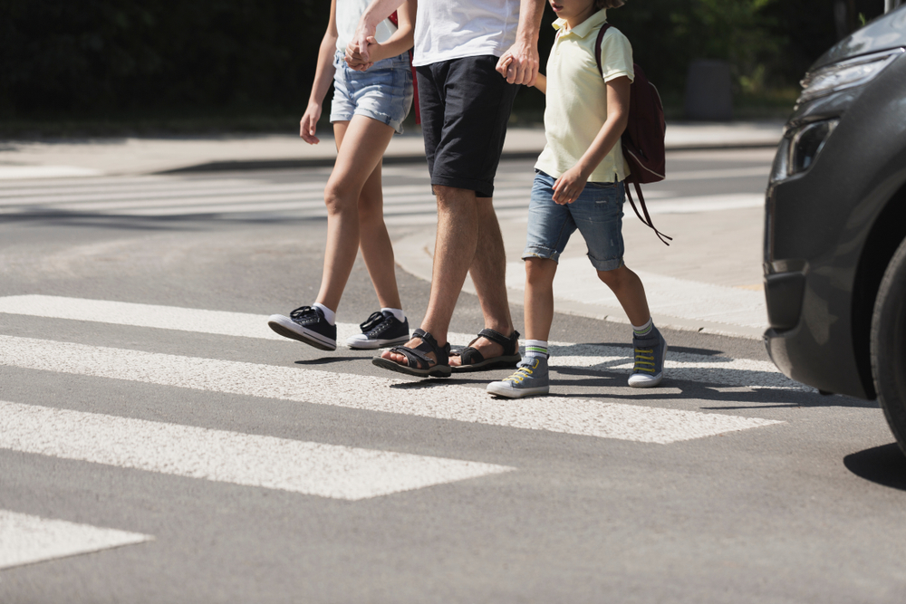 Children crossing the street with their father
