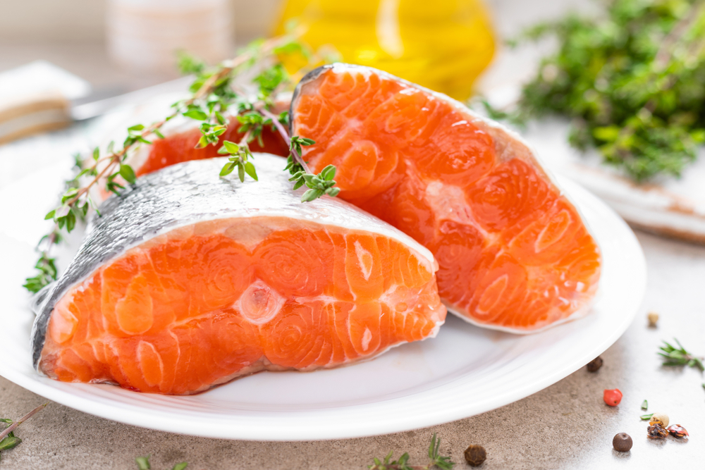 Fresh raw salmon fish steaks on white kitchen background
