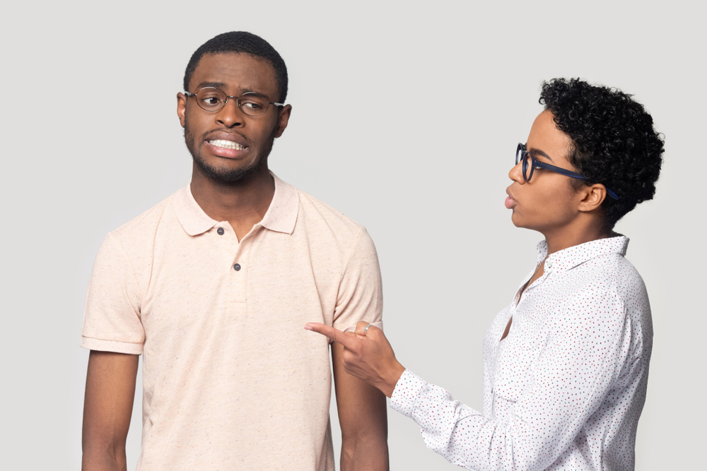 Head shot portrait close up angry girlfriend quarreling with African American boyfriend, young man and woman in glasses, strict teacher talking to unhappy student, isolated on grey background
