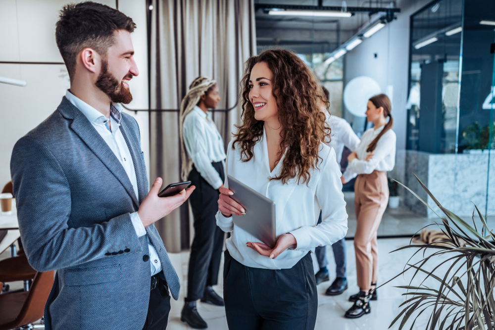 Business professionals. Group of young confident business people talking with each other in the office .Leadership,teamwork and ease atmosphere.
