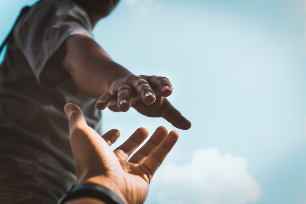 Help Concept hands reaching out to help each other in dark tone.
