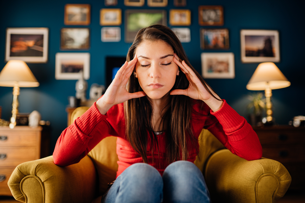 Stressed woman overthinking events alone at home.Thinking of problems.Concentration problems.Brain/cognitive/neurological activity stimulation.Memory loss.Headache,migraine,high blood pressure,anxiety