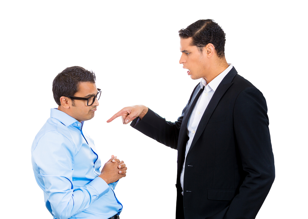 Closeup portrait of rude, mad, giant business man threatening, pointing at his nerdy guy coworker, isolated on white background. Negative emotion facial expression feelings. Office conflict resolution
