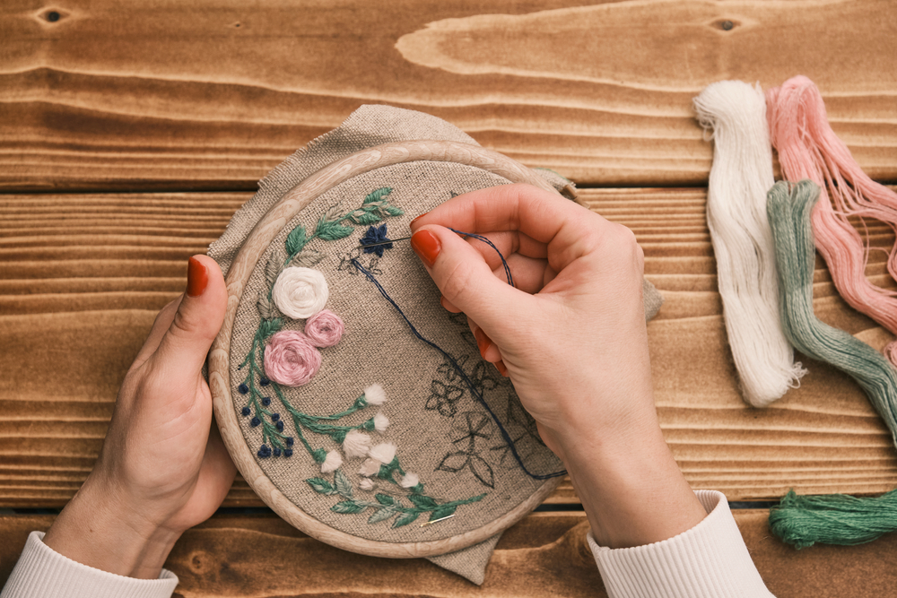 woman's hand is embroidered with tribal native fabric. Sewing pattern. Embroidery in the embroidery frame. Handmade needlework. High quality photo