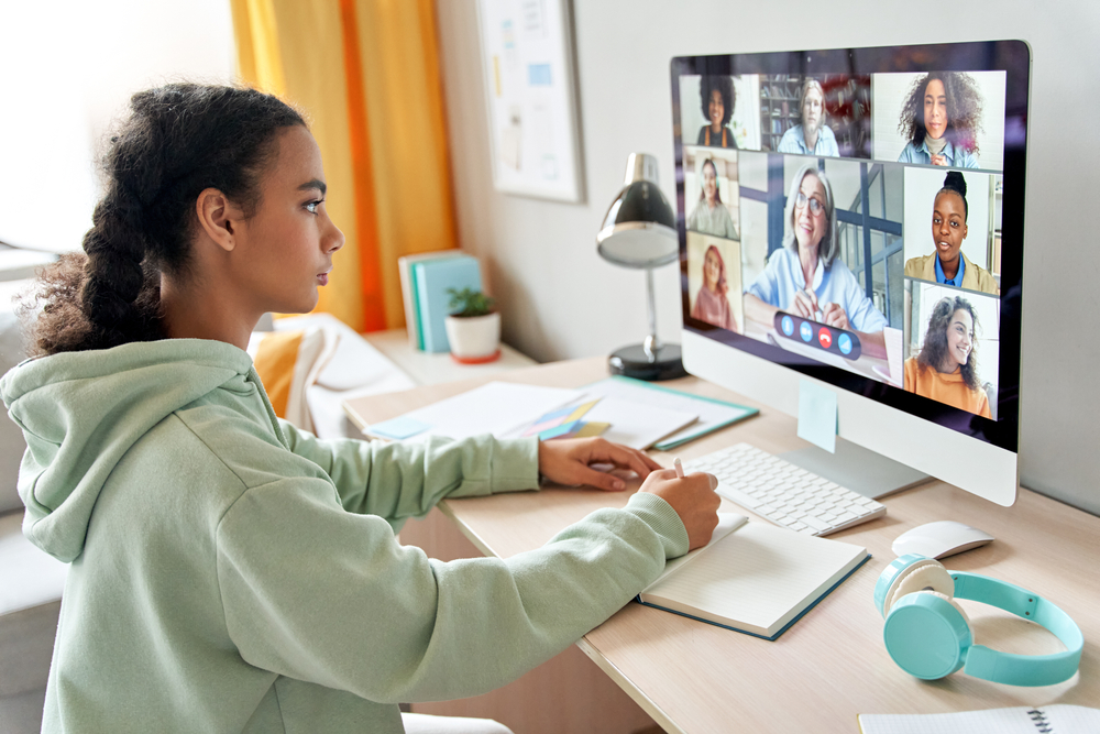 Mixed race teen school girl college student distance learning during virtual remote class, group online lesson on video conference call with teacher on computer screen studying at home by videocall.
