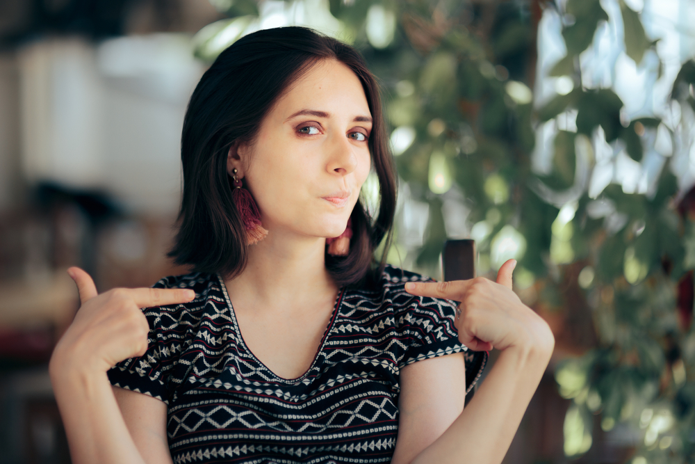 Smug Selfish Vain Woman Pointing to Herself. Presumptuous vain egotistic arrogant person being overconfident and insufferable full of herself
