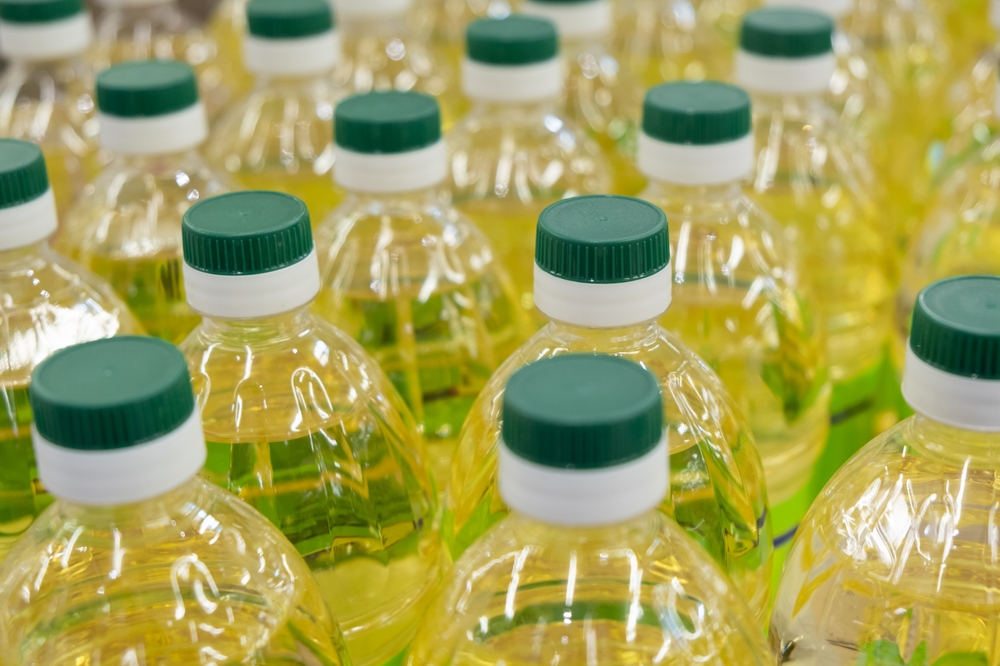 Vegetable rapeseed cooking oil in bottles with cork in the market. Top view
