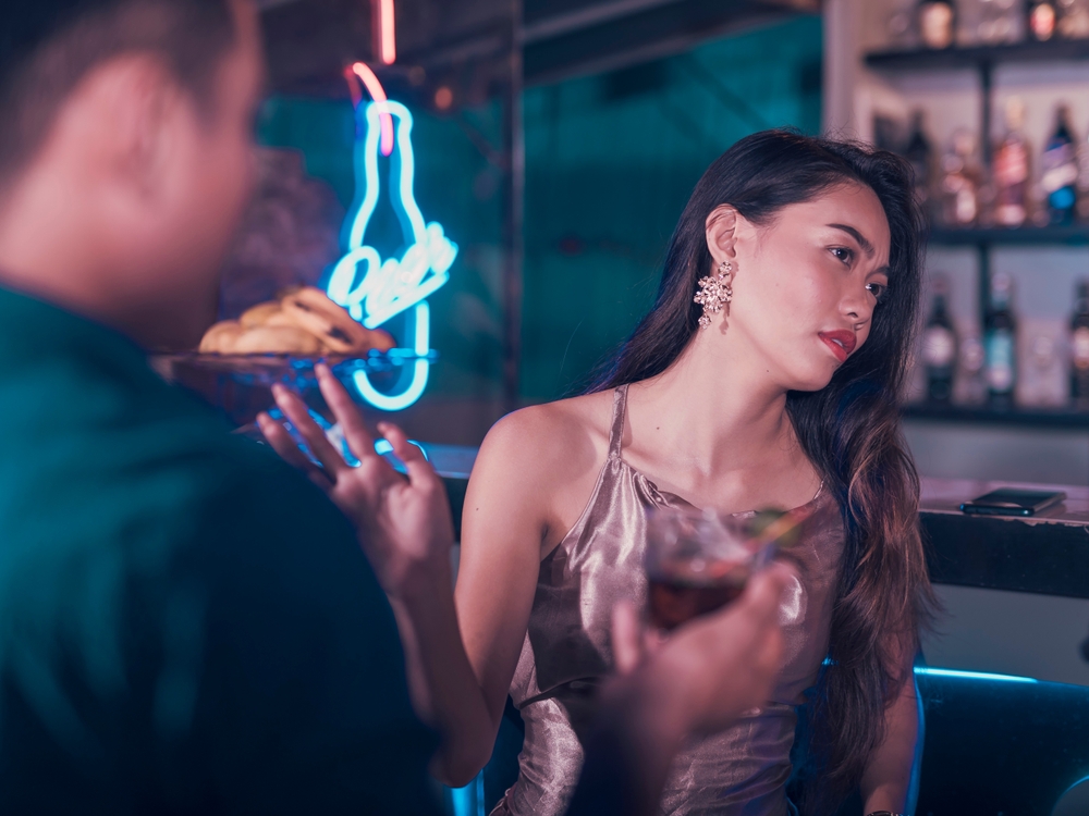 A young woman rebuffs a man trying to hookup with her. Uninterested in meeting new men or turned off at her date.