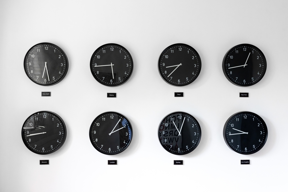 Different times al around the world including Great Britain, Russia and Honk Kong. Eight clocks on wall showing world time zones.

